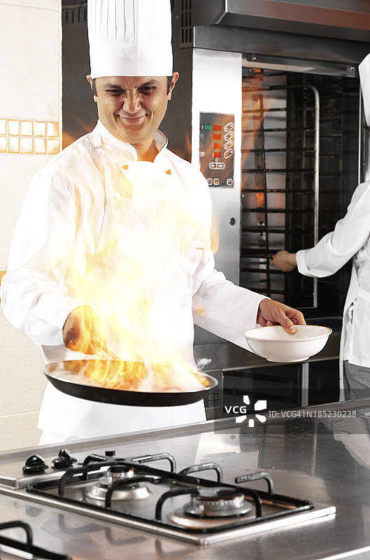 厨师用燃烧的平底锅烹饪图片素材