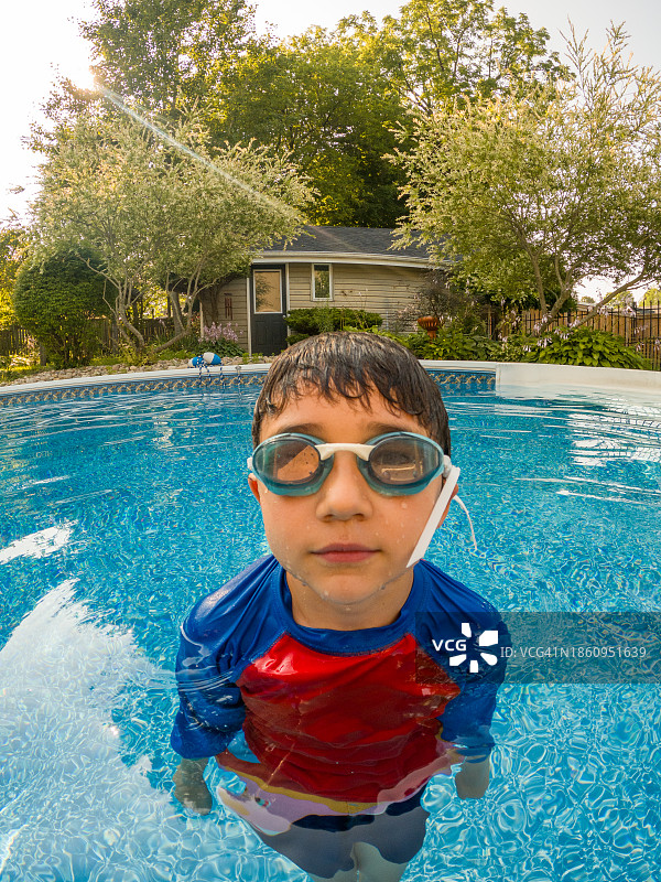 游泳池里混血男孩的广角肖像图片素材