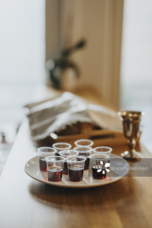 在犹太教堂的餐桌上，酒杯装在盘子里图片素材