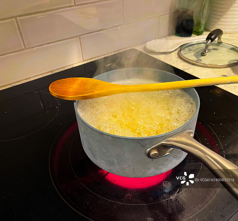 木勺放在沸水锅上图片素材