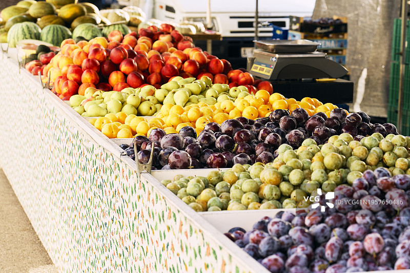 市场上陈列的水果和蔬菜。这些水果颜色各异，形状各异，看起来新鲜健康。图片素材