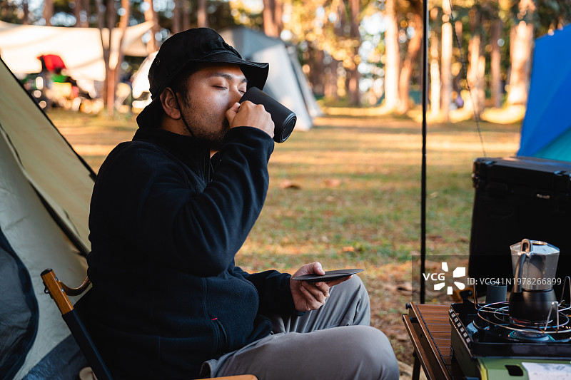 亚洲男人喜欢在早上露营时喝咖啡图片素材