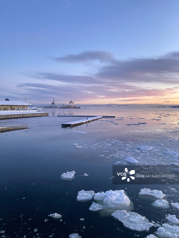 日落时冰冻的海面对着天空的风景，挪威，挪威图片素材