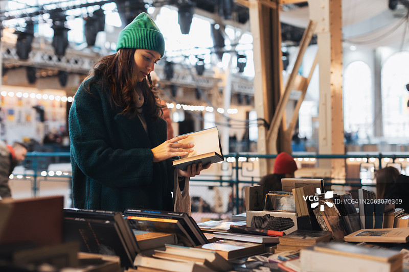 美女在旧货店、二手书店买旧书。Z世代学生在跳蚤市场购物。循环再造、升级再造和环境可持续性的概念。图片素材