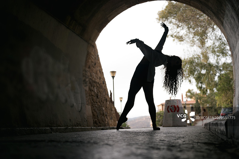 一名芭蕾舞者在隧道内做芭蕾舞姿势。图片素材