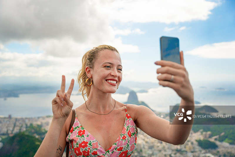 在美丽而神奇的城市里约热内卢和它的著名景点，女人们在自拍和享受假期。巴西里约热内卢的甜面包山。图片素材