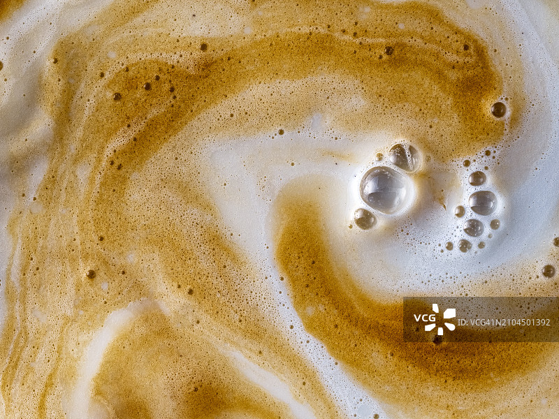 全框杯，牛奶和咖啡在运动中混合。图片素材