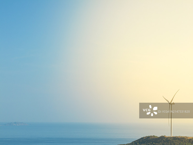 风力发电机或风力涡轮机在室外与阳光和蓝天一起旋转发电，节约和可持续能源的概念。图片素材