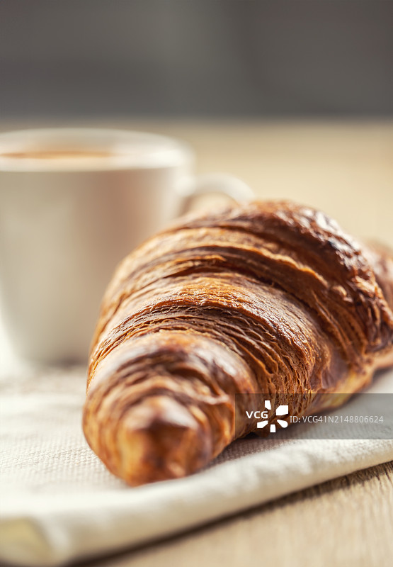 泡芙酥牛角包配咖啡。意式或法式早餐概念。图片素材