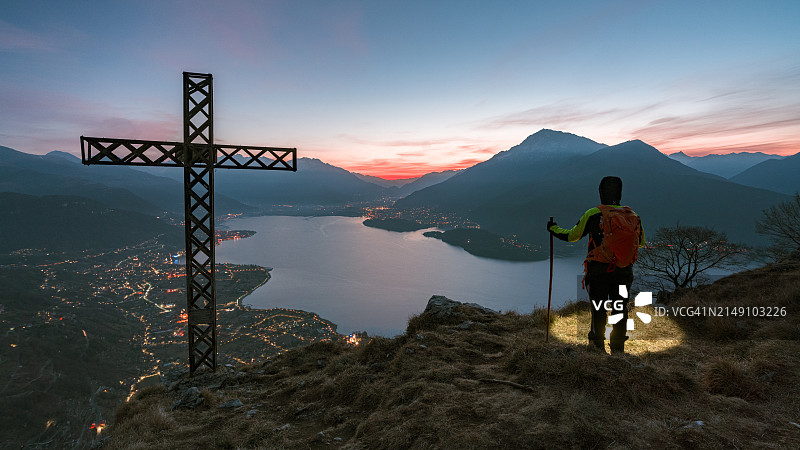 徒步旅行者在日出时在山顶眺望科莫湖图片素材