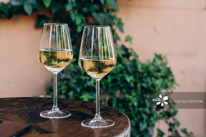 在欧洲城市街头的酒吧里，桌上摆着两杯白葡萄酒或普罗赛克葡萄酒，这是开胃酒时间图片素材