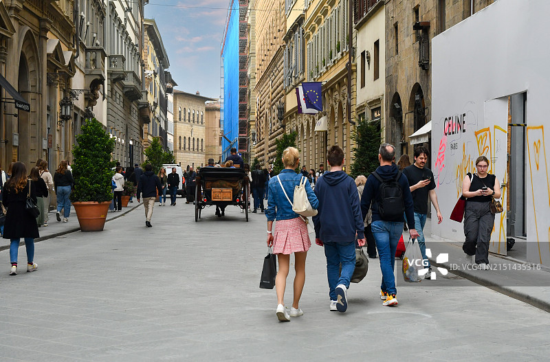 Via de' Tornabuoni街景，这是一条奢侈的街道，以时尚精品店和珠宝店的存在而闻名，春天，意大利托斯卡纳佛罗伦萨，有一辆马车供游客乘坐图片素材
