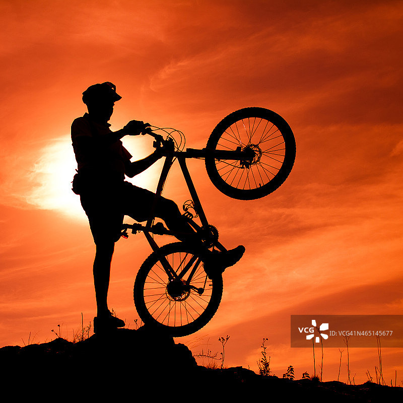日落中骑着自行车的年轻人图片素材