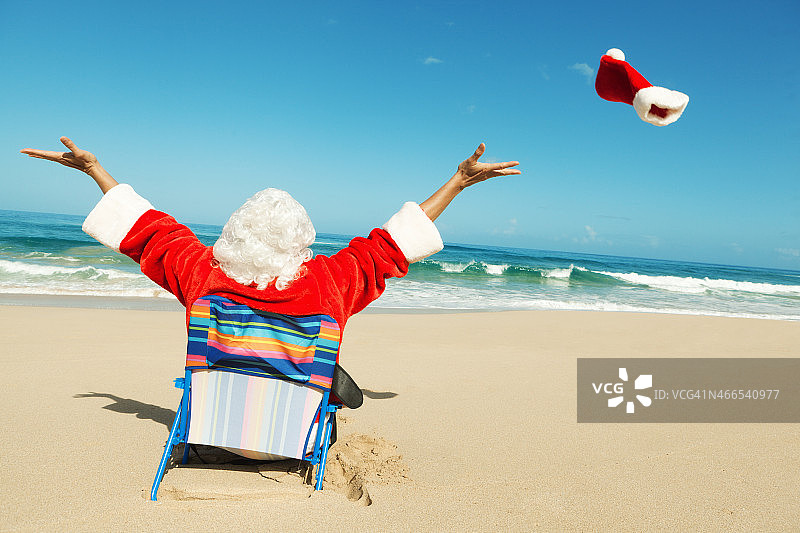 轻松愉快的圣诞老人在热带海滩度假图片素材