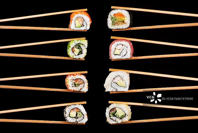 8双筷子夹着寿司卷图片素材