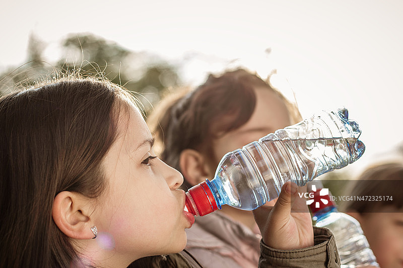 小女孩和朋友喝水的照片图片素材