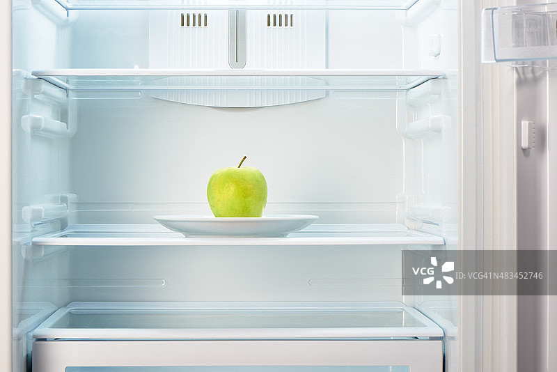 空冰箱里的白盘子上放着青苹果图片素材