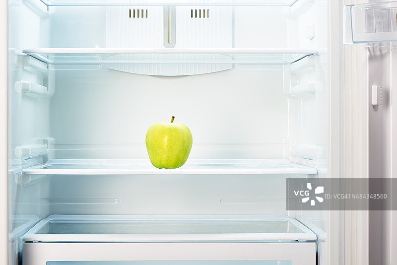 空空如也的冰箱架子上的青苹果图片素材