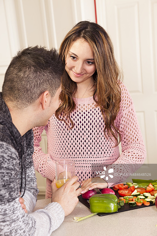 年轻夫妇准备健康的午餐。厨房。水果、蔬菜、沙拉。图片素材