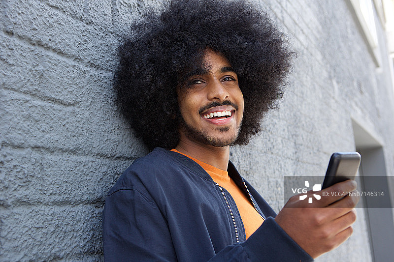 微笑的年轻人与非洲人使用手机图片素材