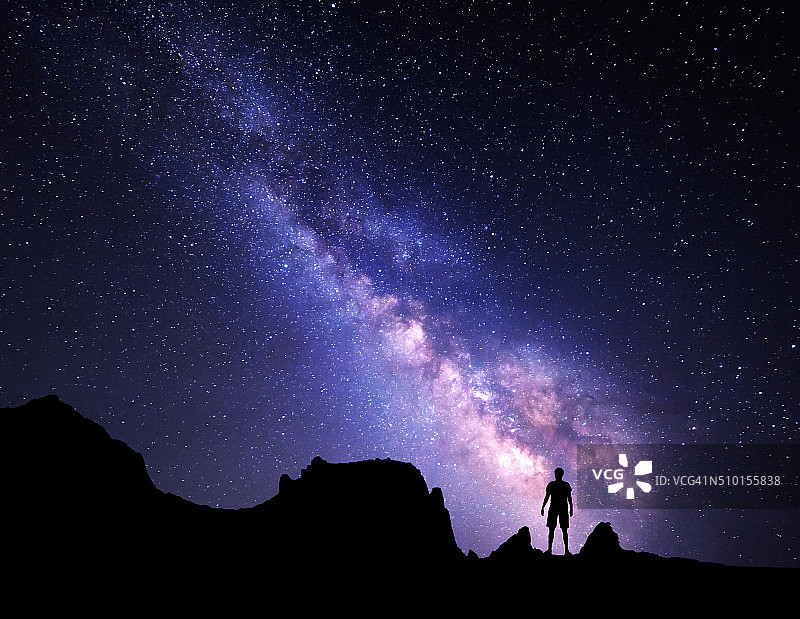 银河系。夜空和一个站立的人的剪影图片素材