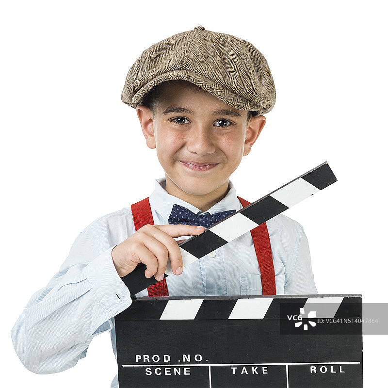 戴着报童帽的小男孩与电影石板摆姿势图片素材