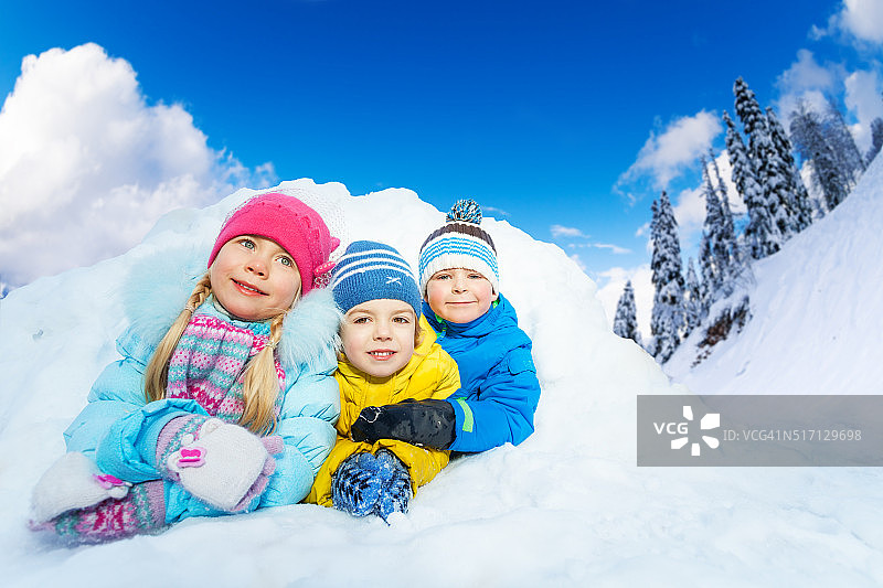 三个小孩在雪洞里微笑图片素材