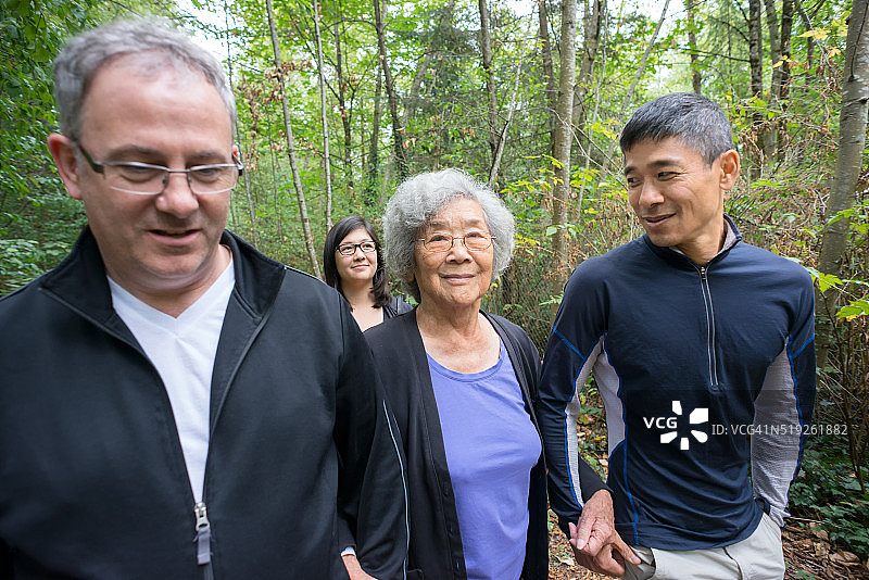 年长的亚洲祖母与儿子，女儿，家人在森林里散步图片素材