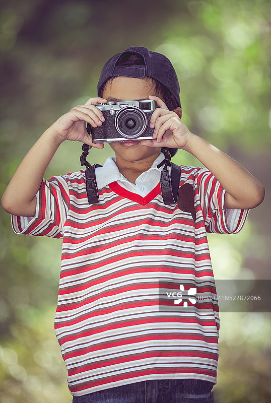 亚洲男孩摄影师与专业数码相机的自然图片素材