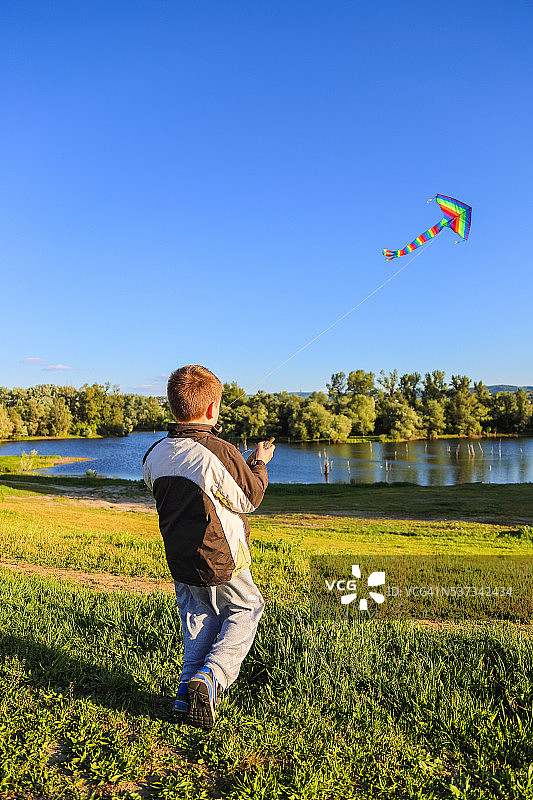 7岁的男孩在天空放风筝图片素材