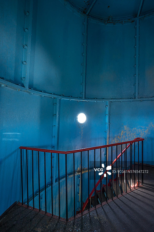 古老的灯塔。红色的铁楼梯，圆窗，蓝色的墙图片素材