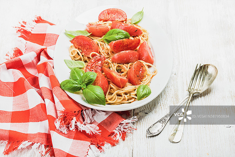 意大利面配烤番茄和新鲜罗勒，白色背景图片素材