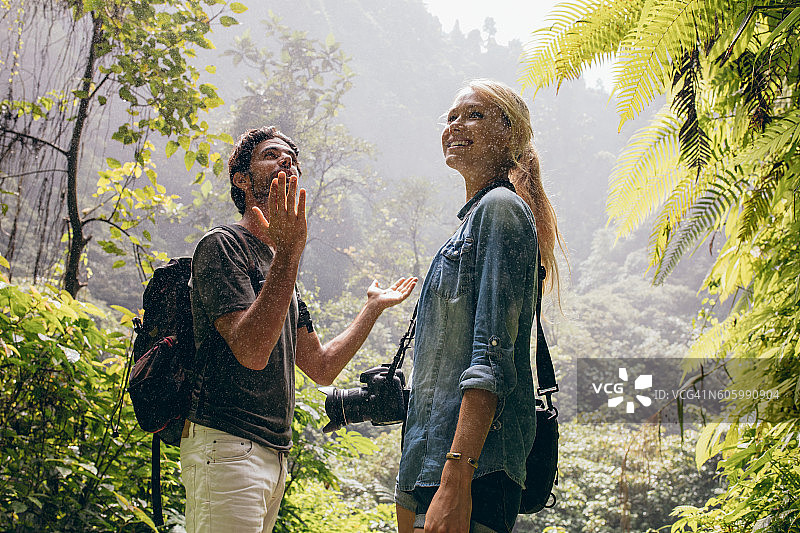 一对游客夫妇在森林里享受雨图片素材