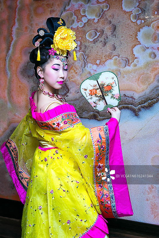 一个穿着中国民族服装半转身站着的中国妇女图片素材