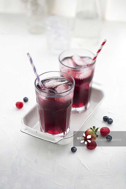白色背景的Berry果汁在饮用玻璃杯。图片素材