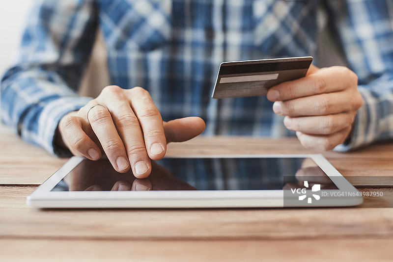 男人用数字平板电脑和信用卡在网上购物图片素材