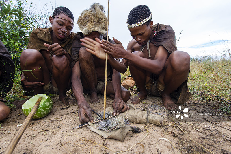 布须曼族人用干草引火，用硬木头和软木头做的木钻生火图片素材