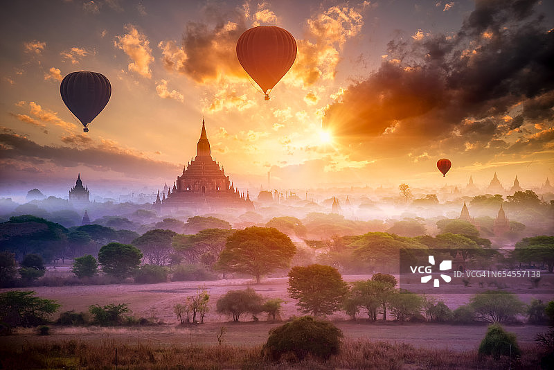 在缅甸曼德勒，雾气蒙蒙的早晨，热气球飞过蒲甘平原图片素材