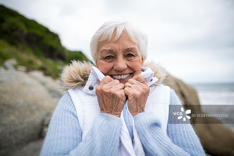 一位老妇人站在海滩上的肖像图片素材