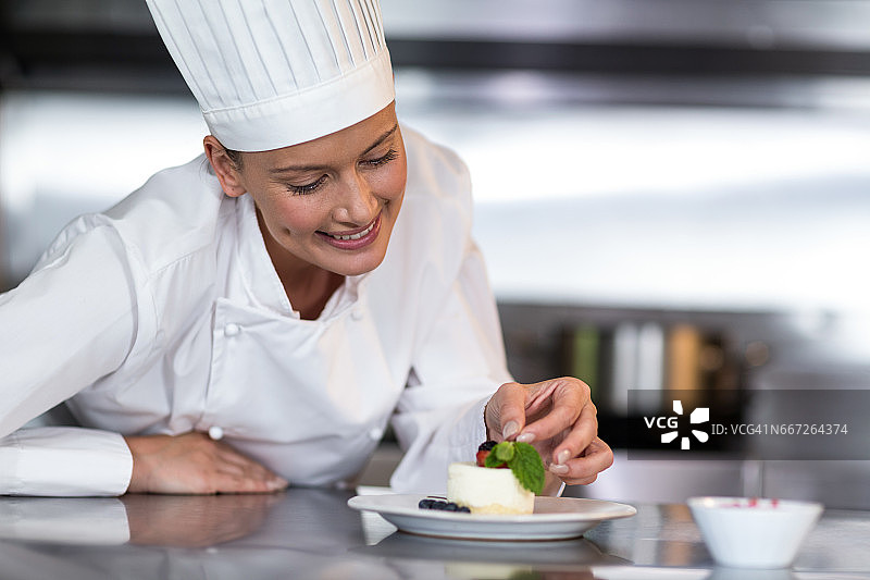 微笑的女厨师在厨房装饰食物图片素材