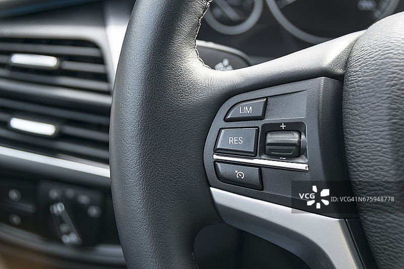 一辆现代汽车方向盘上的巡航控制按钮，车体内饰细节图片素材