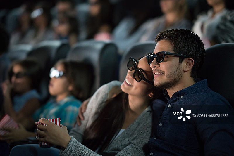 一对夫妇戴着3D眼镜在电影院看电影图片素材