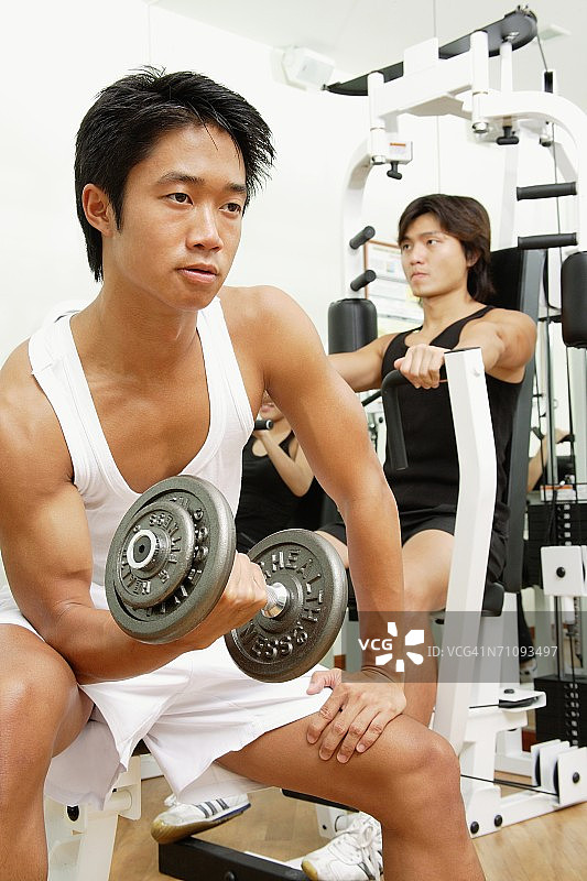年轻人在健身房里锻炼，眼睛睁得远远的图片素材