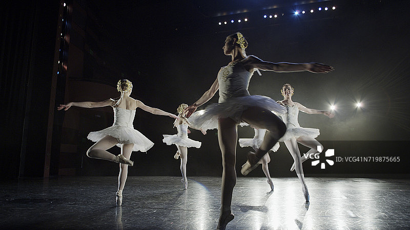 低角度的严肃芭蕾舞者在表演舞台上的服装图片素材