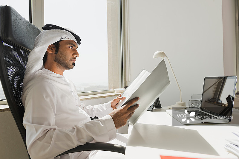 阿联酋商人在办公室阅读文件。图片素材