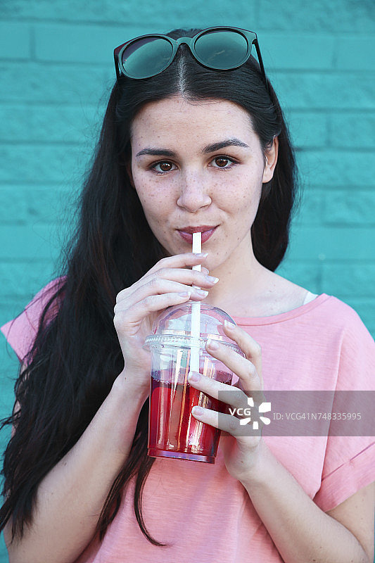 年轻女子喝软饮料的肖像图片素材