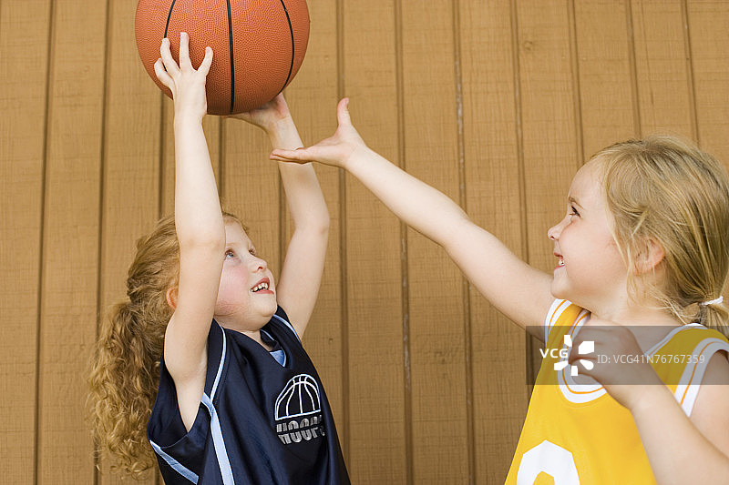 穿着篮球服的女孩们为了篮球而打架图片素材