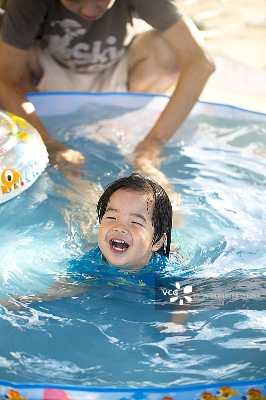 亚洲小孩学习游泳。图片素材