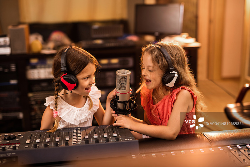 快乐的小女孩们正在电台播放广播节目。图片素材