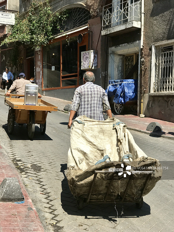 一名土耳其男子在托芬大街上捡垃圾，网址是İstanbul图片素材